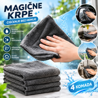 Four dark gray microfiber cleaning cloths, with three folded and one being held by a hand to demonstrate use. The image features promotional text in Serbian ('Magićne Krpe' meaning Magic Cloths), icons highlighting benefits like gentle cleaning and reusable use, and circular inset images showing the cloths being used to wipe mirrors, dishes, and surfaces.